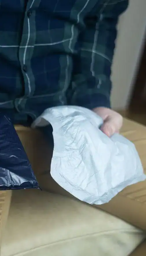 Image of man holding incontinence pads as part of overactive bladder treatment Luton